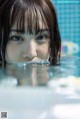 A young woman in a swimming pool looking at the camera.