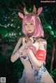 A woman with pink hair wearing a bunny costume.