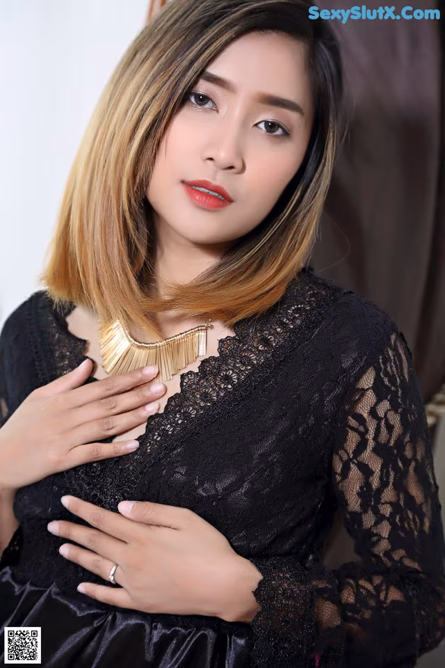 A woman in a black dress posing for a picture.