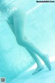 A woman's legs submerged in a swimming pool.