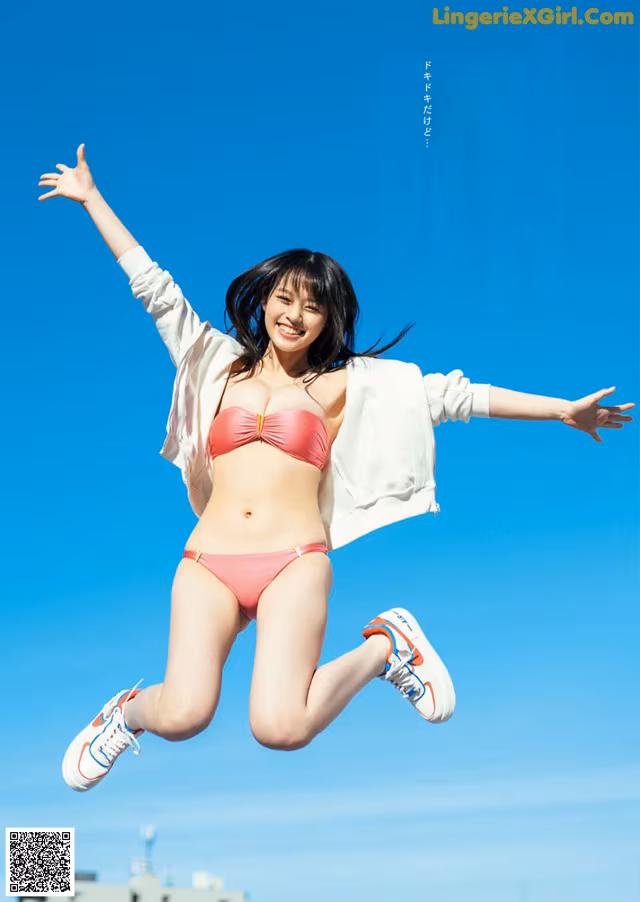 A woman in a pink bikini jumping in the air.