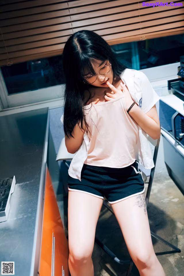 A woman standing in a kitchen next to a counter.