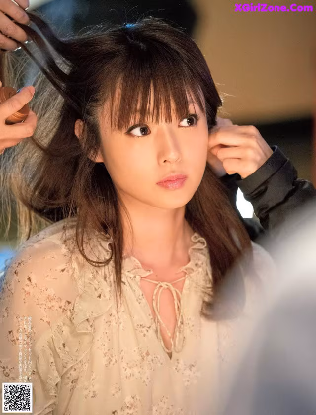 A woman is getting her hair styled by a hairdresser.