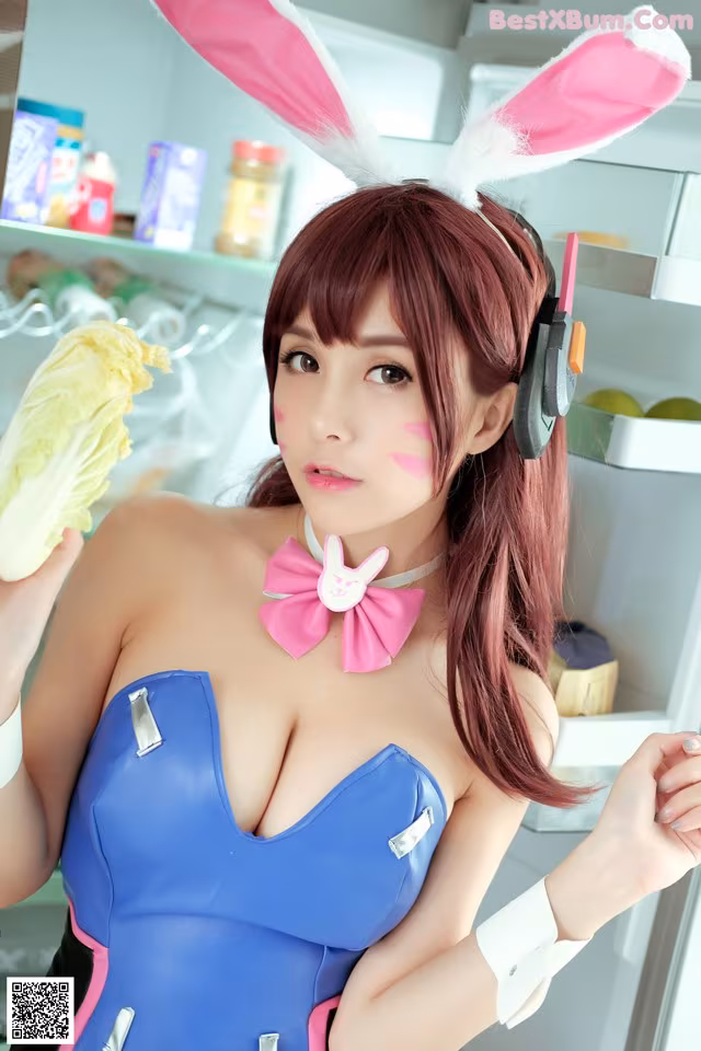 A woman in a bunny costume holding a piece of lettuce.